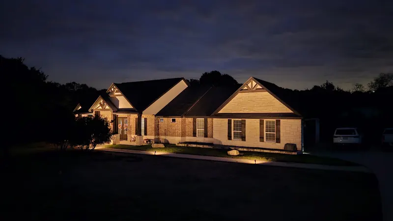 Low-voltage landscape lighting at night in Spring Branch, TX by CJK Landscaping